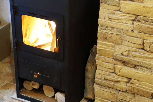 istock burning metal fireplace with wood at the stone wall 1297566977