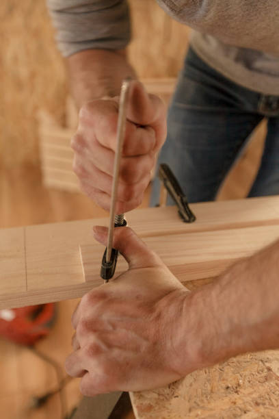 istock Carpenter fastening a plank with clamps for his desk 1297569669