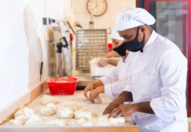 istock Latin american baker forming bread loaves from raw dough 1297569738
