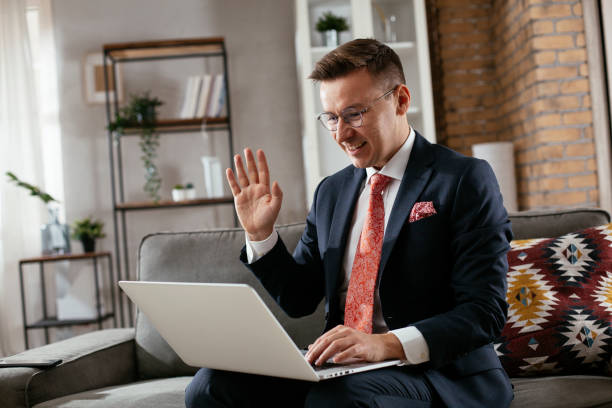 istock Businessman sitting on sofa having video call 1297569854