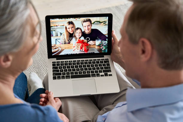 couples de grands-parents retenant la famille d’appel de vidéo d’ordinateur avec le petit-enfant sur l’écran d’ordinateur portatif ayant l’amusement appréciant parler en ligne, saluant avec le cadeau pendant le chat distant virtuel de réunion - grandmother child grandparent isolated photos et images de collection