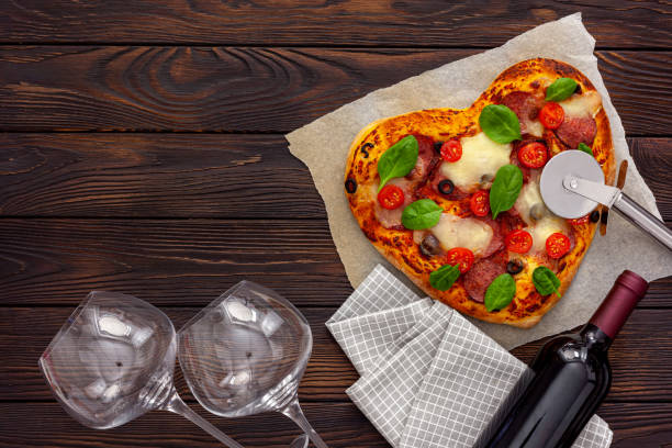 istock Heart pizza with a bottle wine, glasses and gift box 1297570788