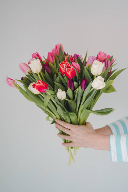 istock woman with tulip bouquet in spring colors 1297570791