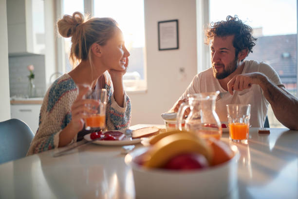 istock A young couple in love chatting while having a breakfast at home. Relationship, love, together, breakfast 1297571059