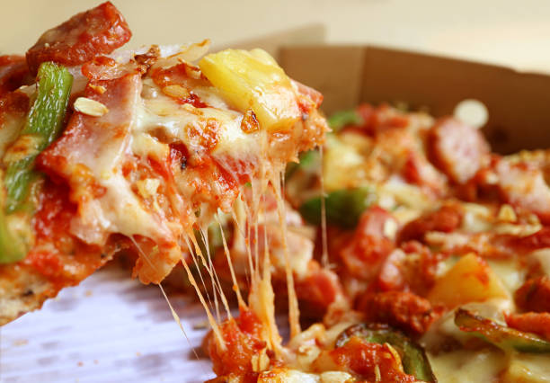 Closeup a Slice of Mouthwatering Pizza with Stretching Cheese Being Taken from Paper Box