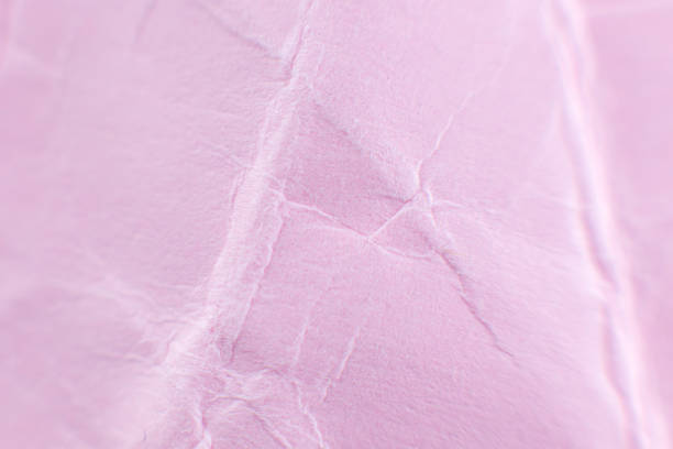 istock Crumpled pink paper background. Real macro battered texture. Close up photo. 1297572422