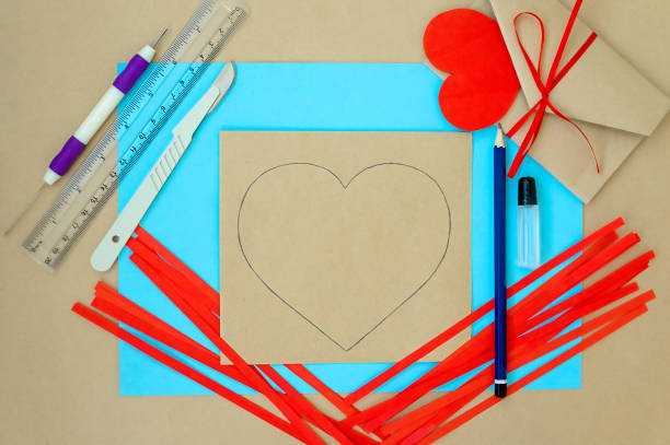 발렌타인 데이를 위한 공예품. 퀼링 방법을 사용하여 심장을 만드는 것입니다. 하트가 있는 카드를 만들기 위한 단계별 지침입니다. 4단계 - 엽서 나 판지에 심장 윤곽을 간략하게 설명합니다. - pencil colors heart shape paper 뉴스 사진 이미지
