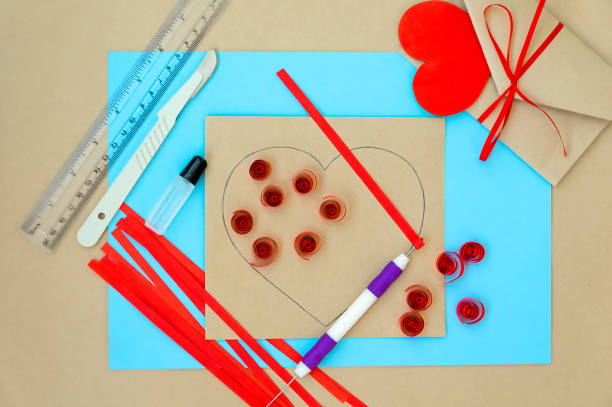 발렌타인 데이를 위한 공예품. 퀼링 방법을 사용하여 심장을 만드는 것입니다. 하트가 있는 카드를 만들기 위한 단계별 지침입니다. 5단계 - awl을 사용하여 종이 스트립에서 나선형 형성 - pencil colors heart shape paper 뉴스 사진 이미지