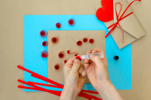 발렌타인 데이를 위한 공예품. 퀼링 방법을 사용하여 심장을 만드는 것입니다. 하트가 있는 카드를 만들기 위한 단계별 지침입니다. 6 단계 - 접착제로 나선형 스트립의 끝을 수정합니다. - pencil colors heart shape paper 뉴스 사진 이미지