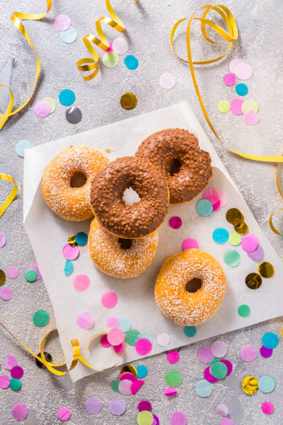 istock Donuts for carnival and party. Donuts with streamers and confetti 1297574682