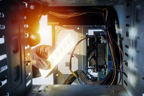 istock male person or technician worker installing ddr ram memory module to a desktop pc case. close up. looking inside computer case. appliance service concept 1297576885