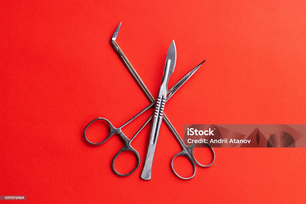 medical equipment for surgery over red desk background with copy space. surgery concept medical equipment for surgery over red desk background with copy space. surgery concept. Scalpel Stock Photo