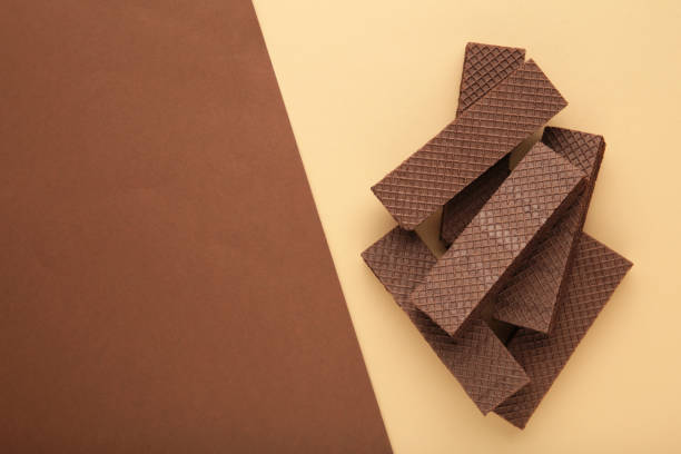 istock Chocolate wafers with coffee on beigeand brown background. 1297578056