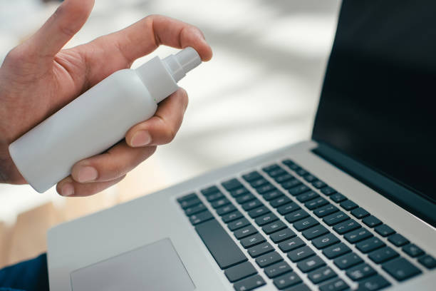 istock young man decontaminating his laptop with antiseptic 1297584728