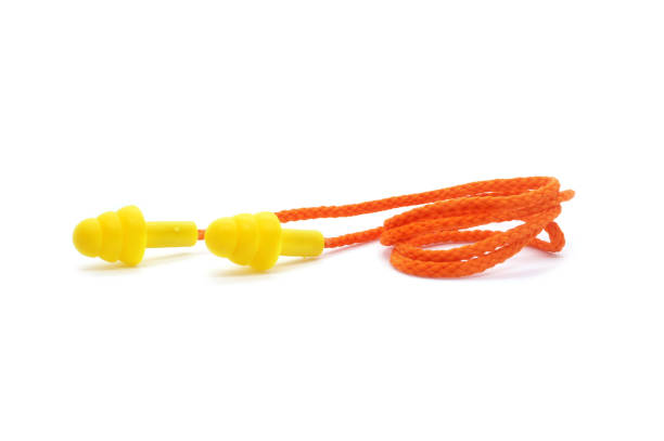 istock Yellow silicone earplugs with cord isolated on white background. Noise isolation and protection. Close-up. 1297585332
