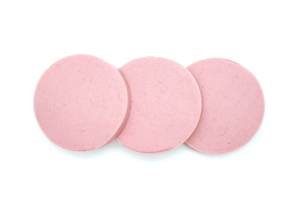 istock Sausage cut into three pieces. Sliced sausage isolated on white background. Fresh cut boiled pieces. Top view. 1297585352