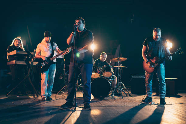 istock Rock and roll band performing hard rock music on stage 1297585385