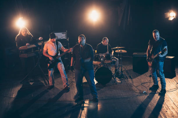 istock Rock and roll band performing hard rock music on stage 1297586701