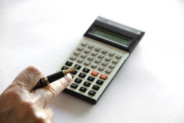 Hand with pen typed on a calculator.