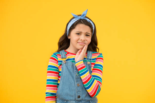 maladie dentaire. maux de dents comme douleur dentaire. prévoyez de consulter un dentiste. rendez-vous chez le dentiste. le petit enfant souffrent du fond jaune de mal de dents. remède anti-maux de dents. analgésique mal de dents. soulagement de la doul - rage de dents photos et images de collection