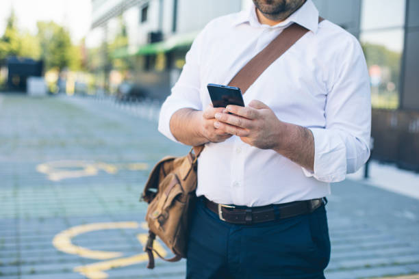 istock Businessman using a mobile phone at parking lot 1297591341
