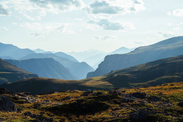 Scenic mountain landscape with giant rockies and deep gorge behind green hill in sunlight. Wonderful vivid sunny highland scenery with big rocks and precipice. Awesome view to great mountains. Scenic mountain landscape with giant rockies and deep gorge behind green hill in sunlight. Wonderful vivid sunny highland scenery with big rocks and precipice. Awesome view to great mountains. rocky mountains stock pictures, royalty-free photos & images