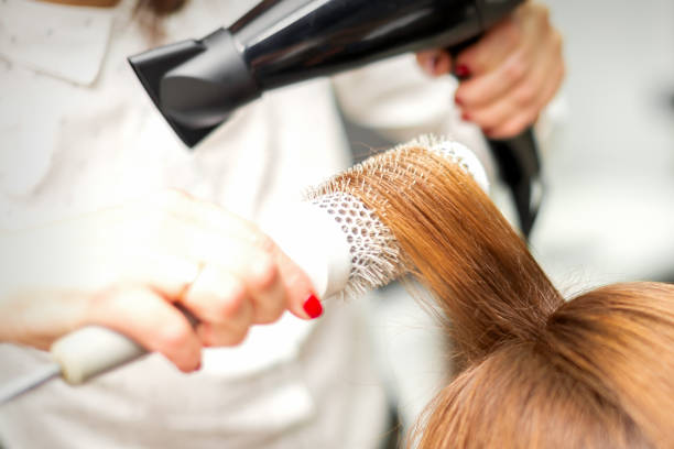 istock Hairdresser drying long red hair 1297591663