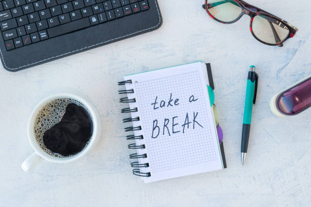 istock Take a break. Concept time off. Words Take a break in notebook on the working table with cup of coffee 1297592922