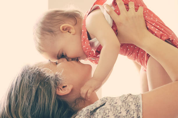 istock Happy mom holding baby in arms 1297594036