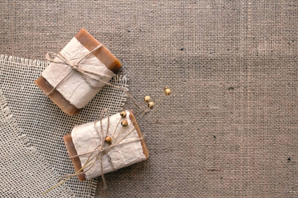 istock Top view on handmade natural soap bars or dry shampoo with on rustic fabric background with copy space. Close up of home spa products made with natural ingridients and organic essential oils 1297594096