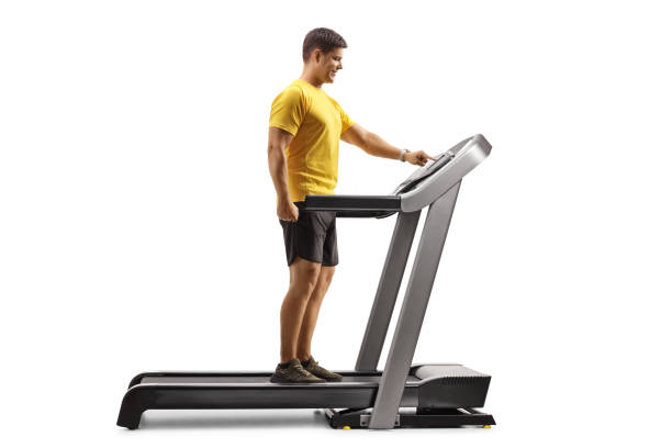 istock Full length profile shot of a young man pushing a button on a treadmill 1297594220