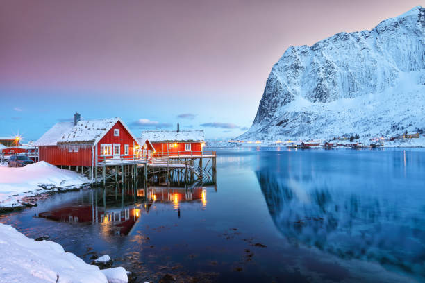 Popular travel destinations on Lofotens islands in Norway Dramatic evening cityscape of Reine town. Red rorbuers on the shoore of Reinefjorden. Popular travel destination on Lofotens.  Location: Reine, Lofoten; Norway, Europe reine lofoten stock pictures, royalty-free photos & images