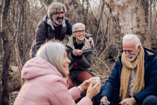 istock Senior friends having fun and drinking coffee in the forest 1297599073