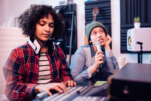 istock Two young musicians using sound mixer to make electronic music 1297599138