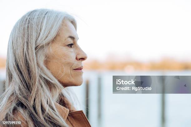 Headshot Of A Thoughtful Mature Woman Looking At The Distance Stock Photo - Download Image Now