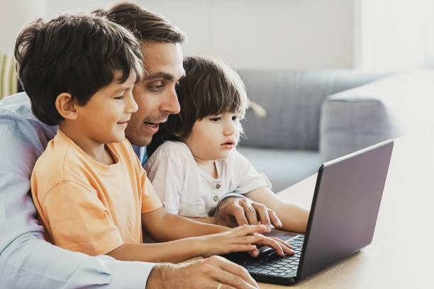 istock Exited father showing something on laptop to little sons 1297599327