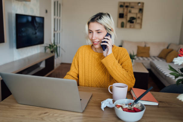 istock Young female freelancer working online and telephoning 1297599403