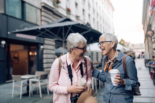 istock Two senior friends on a journey drinking coffee and enjoying their walk 1297601082