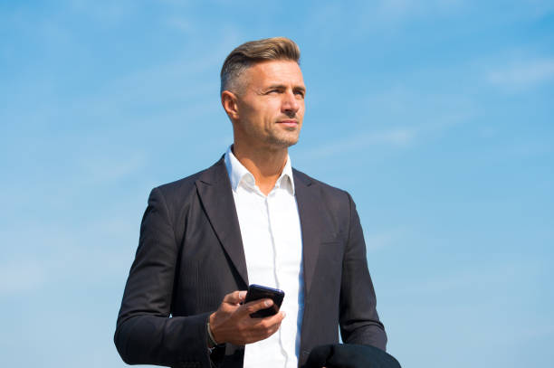 istock Communicating on the go. Handsome man hold mobile phone outdoors. Business communication. Mobile marketing. Mobile technology. Video call. 4G. 3G. Mobile lifestyle. Modern life 1297601896