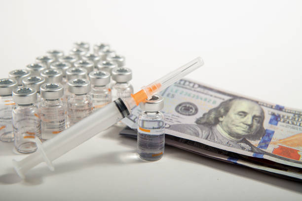 istock Corona Virus vaccine tube, ejector and dollar 1297602347
