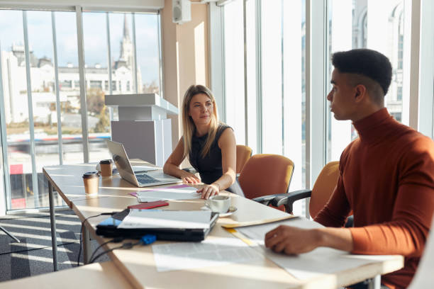 istock young multiethnic colleagues talking in the bright office, looking each other 1297602553