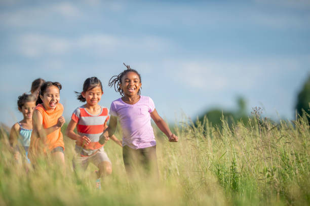 istock Kids running and laughing in a meadow 1297603634