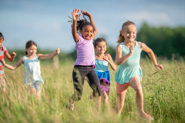 istock Kids running and laughing in a meadow 1297603641
