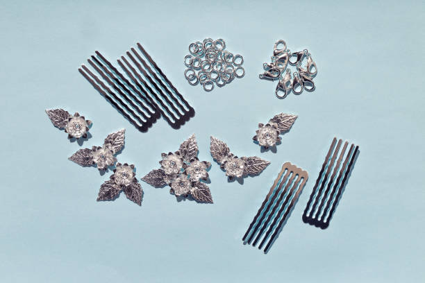 istock Materials for creating jewelry at home. Handmade elements - combs, rings, locks, metal flowers on a simple blue background 1297603703