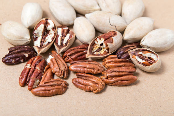 istock The kernel of pecans in the shell. Peeled, whole and half delicious nuts on a cardboard background. 1297604121