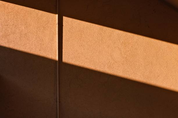 istock A small utility pipe snapped to an orange wall with lights and shadows (Pesaro, Italy, Europe) 1297604230