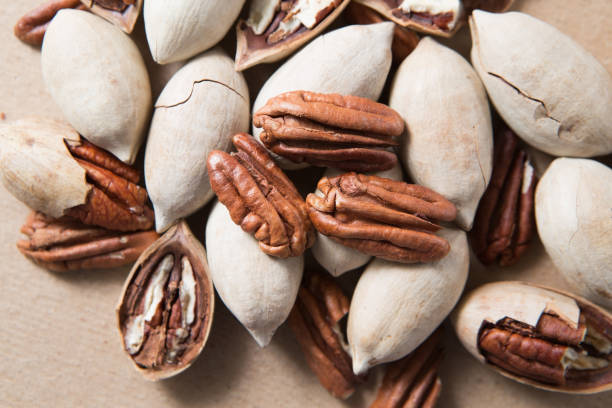 A handful of pecans close up on a cardboard background
