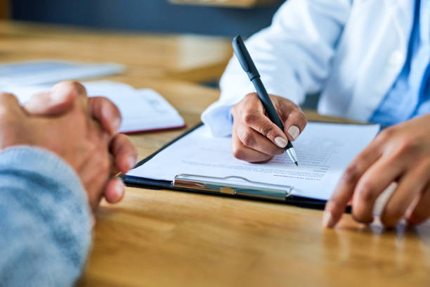 Compiling a thorough plan towards her patient's healing Closeup shot of a doctor writing notes during a consultation with a patient form filling photos stock pictures, royalty-free photos & images
