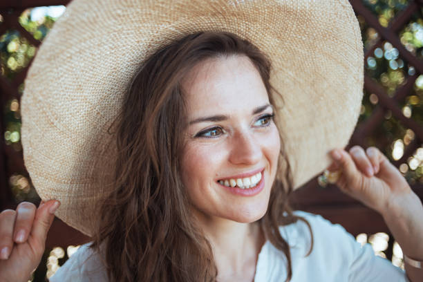 istock happy modern woman in white shirt with hat 1297607603
