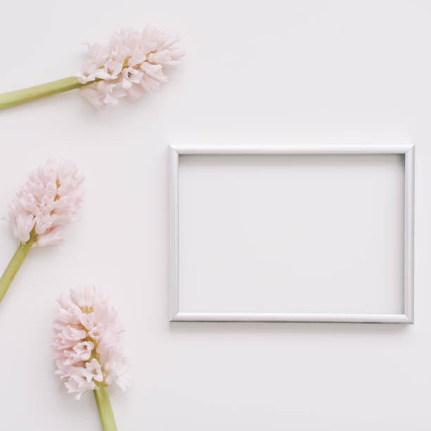 istock Wedding or birthday flat lay composition with pink flowers and blank photo frame, mockup, invitations. top view, copy space. 1297607626